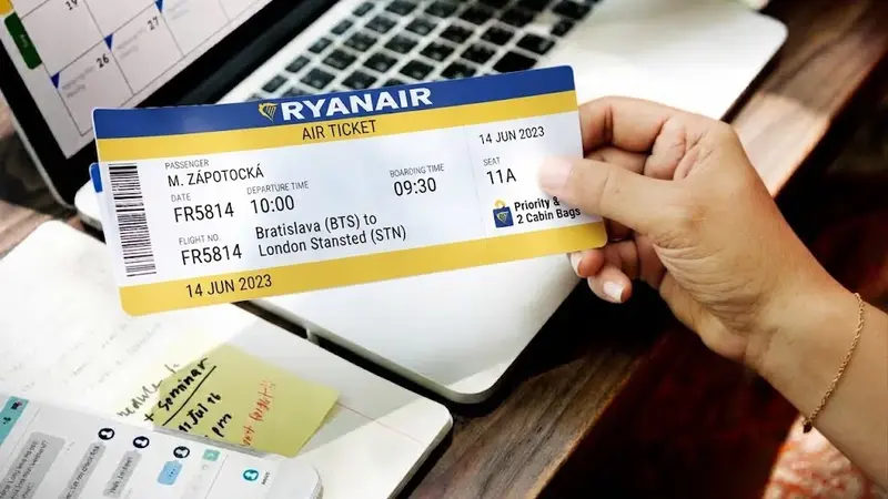 Ruka drží letenku Ryanair s číslem letu FR5814 z Prahy do Londýna Stansted